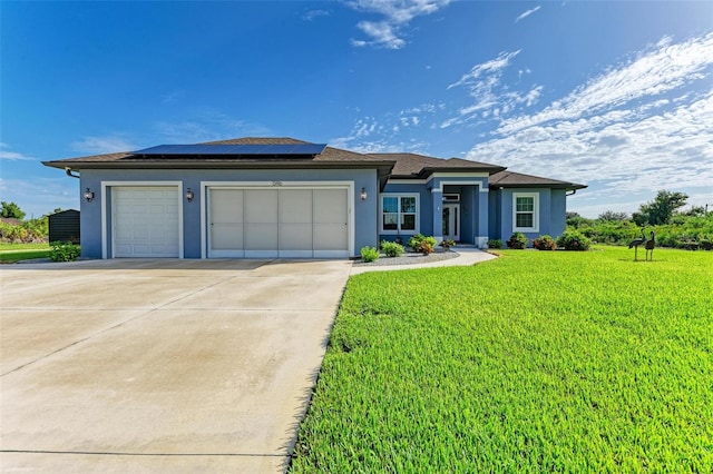 view of front of property featuring solar panels, a garage, and a front yard