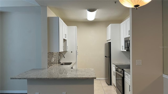 kitchen featuring stainless steel appliances, white cabinetry, light tile patterned floors, sink, and kitchen peninsula