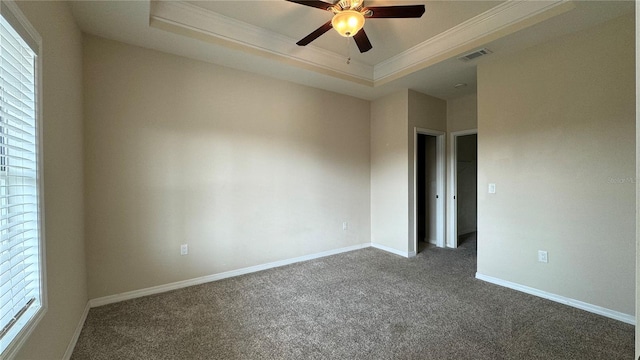 spare room with ceiling fan, a raised ceiling, crown molding, and carpet floors