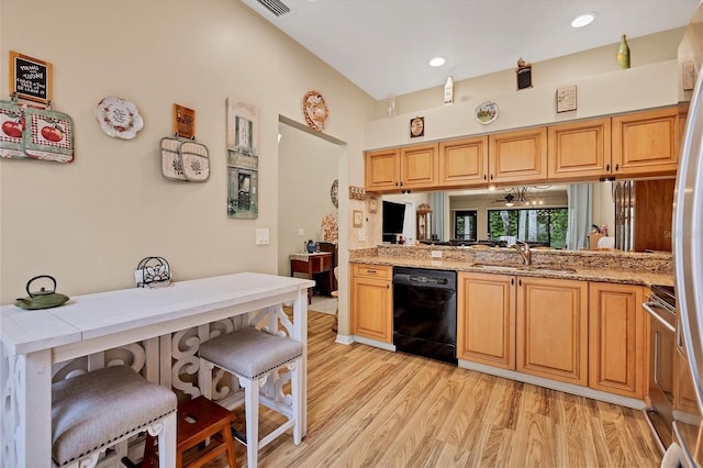 kitchen with dishwasher, light wood-type flooring, light stone counters, sink, and a kitchen breakfast bar