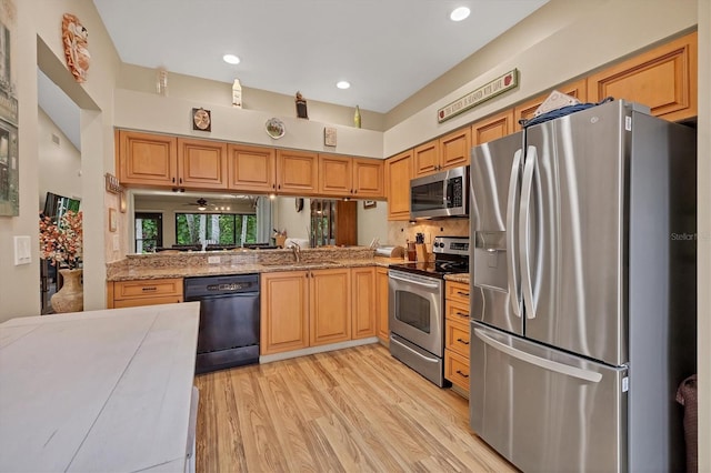 kitchen featuring a towering ceiling, stainless steel appliances, light hardwood / wood-style floors, and sink