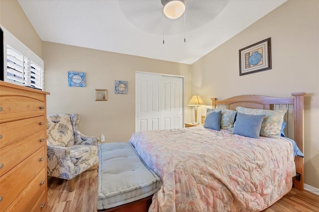 bedroom featuring a closet, wood-type flooring, vaulted ceiling, and ceiling fan