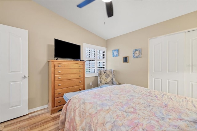 bedroom featuring light hardwood / wood-style flooring, a closet, ceiling fan, and vaulted ceiling