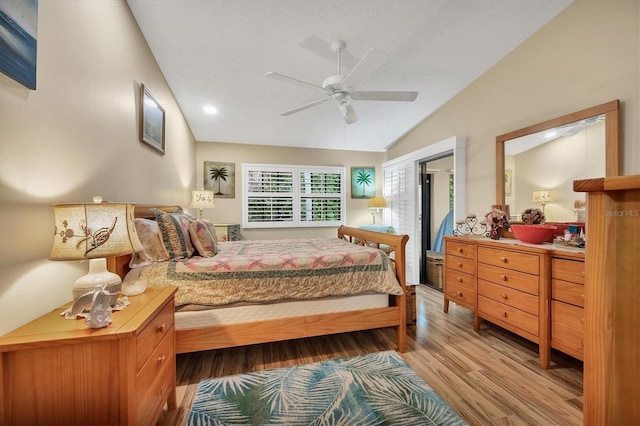 bedroom with lofted ceiling, ceiling fan, hardwood / wood-style floors, and a textured ceiling