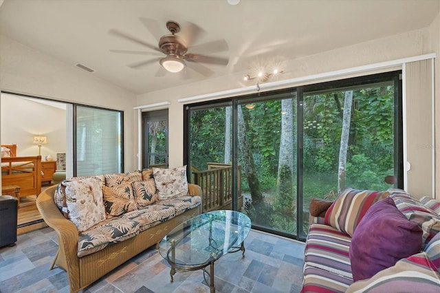 living room with lofted ceiling, a baseboard heating unit, and ceiling fan