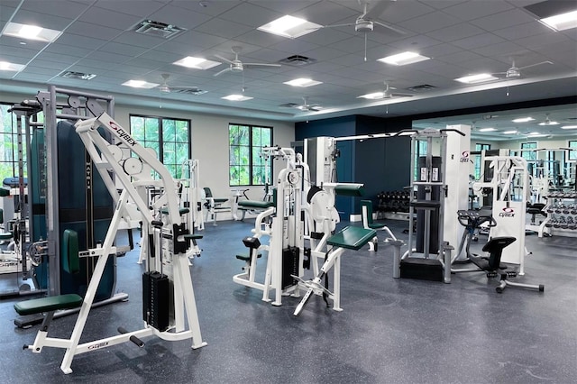 exercise room featuring ceiling fan and a drop ceiling