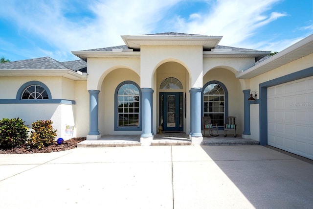 doorway to property with a garage and a porch