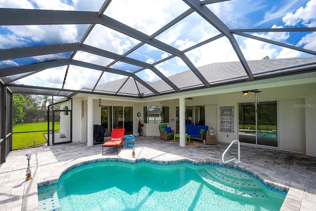 view of pool featuring a patio, outdoor lounge area, ceiling fan, and glass enclosure