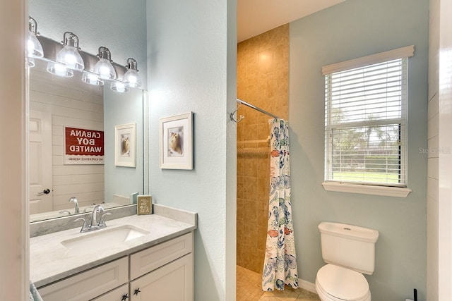 bathroom with toilet, a shower with shower curtain, a healthy amount of sunlight, tile patterned floors, and vanity