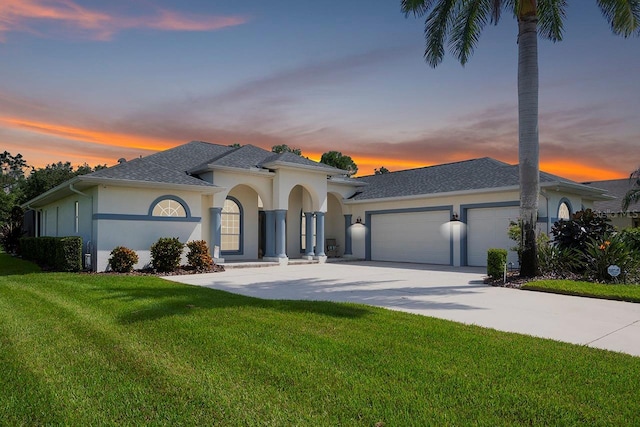 mediterranean / spanish house featuring a yard and a garage