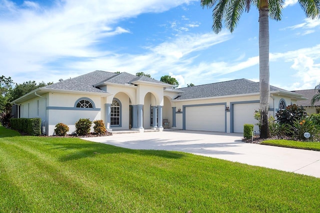 mediterranean / spanish-style house featuring a front yard, concrete driveway, a garage, and stucco siding