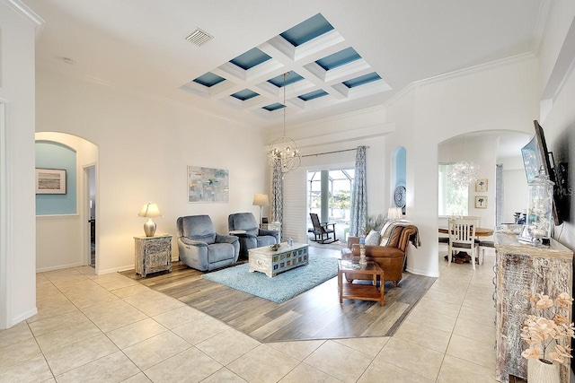 living area with light tile patterned floors, arched walkways, and an inviting chandelier