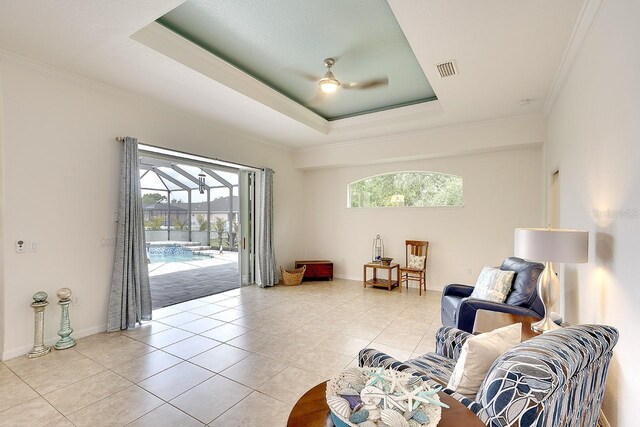 living area with ornamental molding, ceiling fan, and plenty of natural light