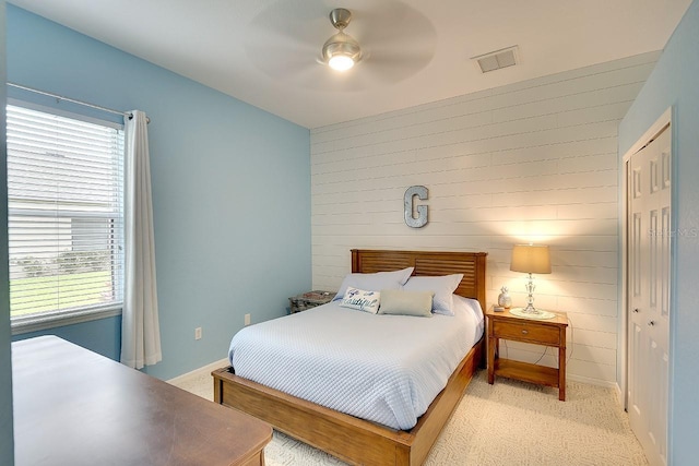 bedroom with a closet, light carpet, baseboards, visible vents, and a ceiling fan