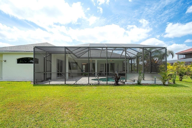 rear view of house with a patio, an outdoor pool, a lanai, stucco siding, and a yard