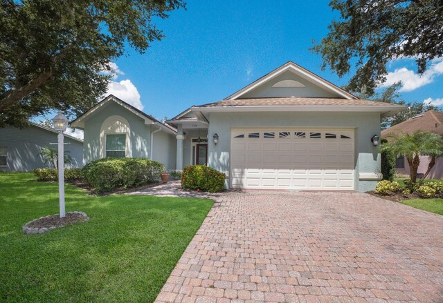 single story home featuring a front lawn and a garage