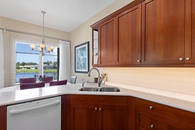 kitchen with sink, dishwasher, backsplash, a water view, and an inviting chandelier