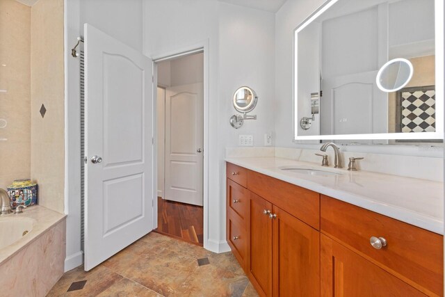 bathroom with vanity and a bath