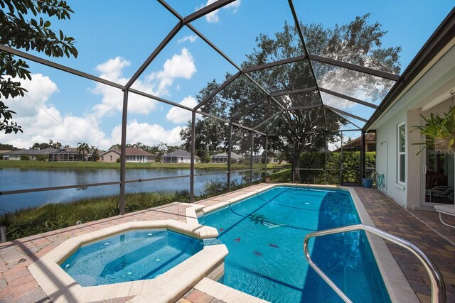 view of pool featuring a water view, an in ground hot tub, glass enclosure, and a patio