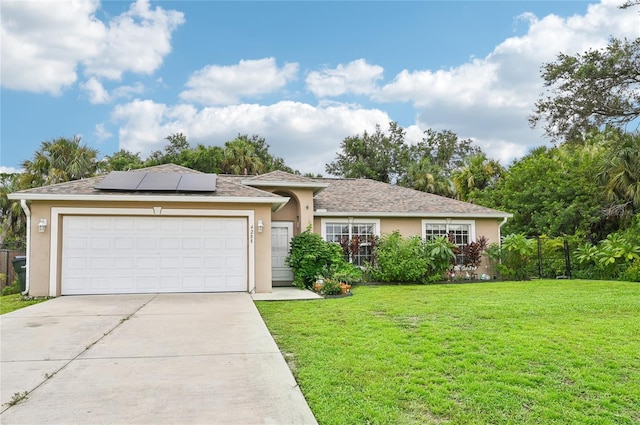 ranch-style house with driveway, a garage, roof mounted solar panels, a front lawn, and stucco siding