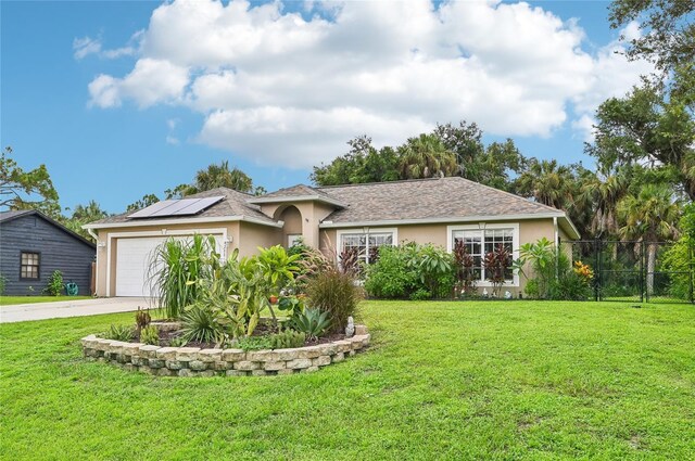 ranch-style house featuring solar panels, a front yard, and a garage