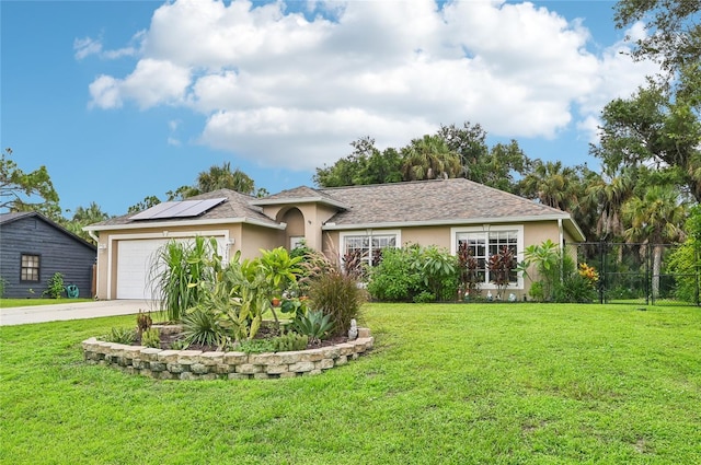 single story home featuring stucco siding, solar panels, concrete driveway, a front yard, and fence