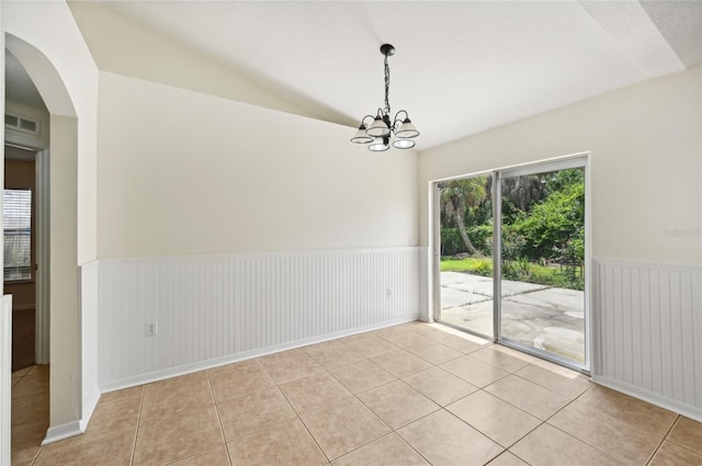 tiled spare room with a chandelier and lofted ceiling