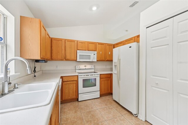 kitchen featuring lofted ceiling, sink, white appliances, and light tile patterned floors