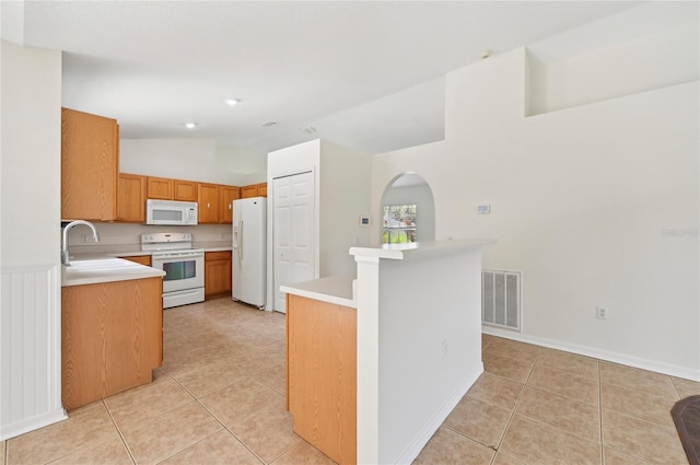 kitchen featuring white appliances, high vaulted ceiling, sink, and light tile patterned floors