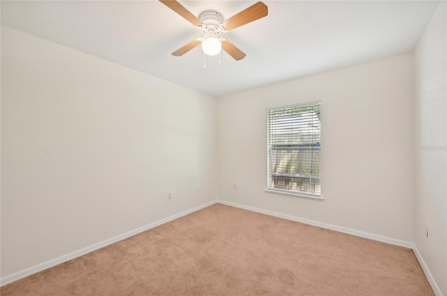 spare room with ceiling fan and light colored carpet