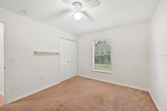 unfurnished room featuring ceiling fan and light colored carpet