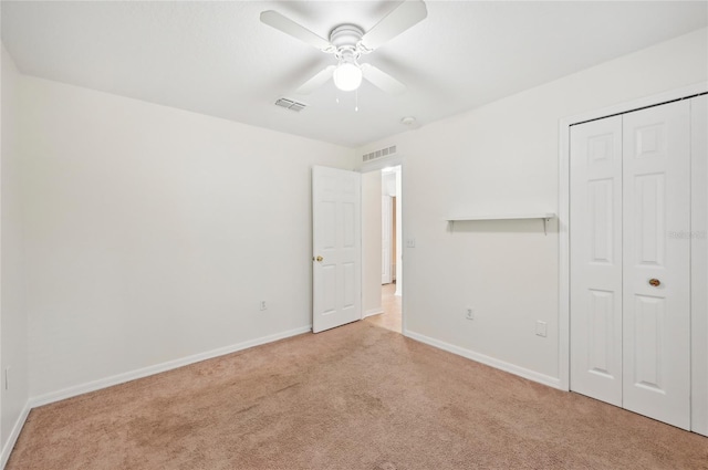 unfurnished bedroom with ceiling fan, a closet, and light colored carpet