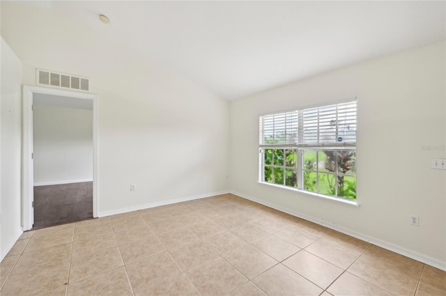 empty room featuring light tile patterned floors, baseboards, and visible vents