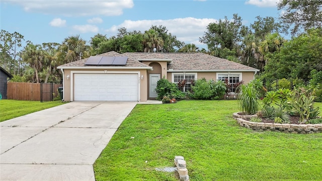 ranch-style home featuring driveway, an attached garage, roof mounted solar panels, a front lawn, and stucco siding