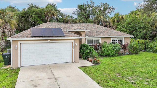 ranch-style house with a front yard, solar panels, and a garage