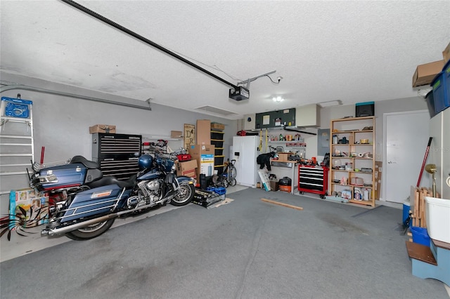 garage with a garage door opener, white refrigerator with ice dispenser, and a workshop area