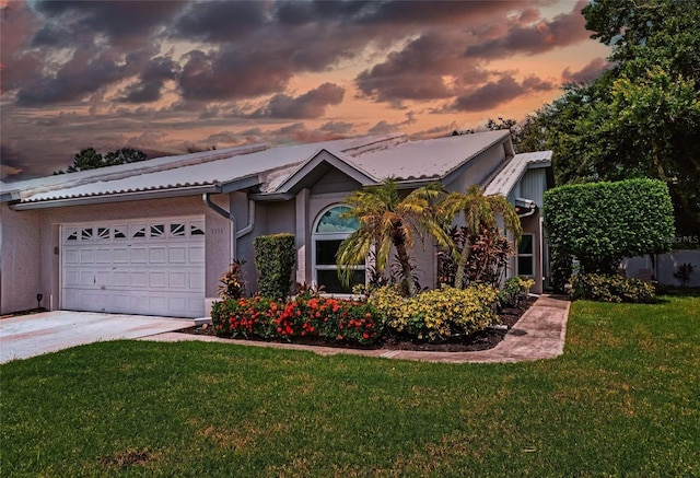 view of front of property featuring a garage and a yard