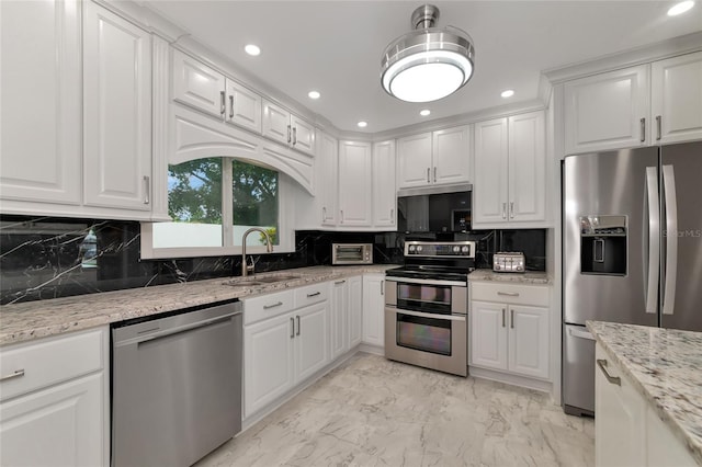 kitchen with sink, white cabinetry, light stone counters, stainless steel appliances, and decorative backsplash