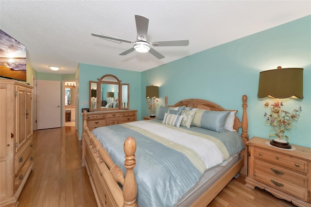 bedroom featuring ceiling fan, a textured ceiling, and light wood-type flooring