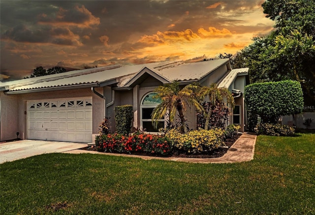 view of front of house with a garage and a yard