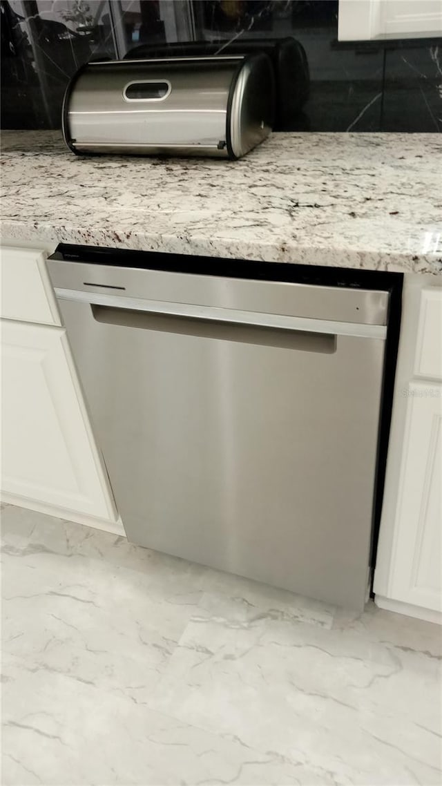 interior details with dishwasher and white cabinets