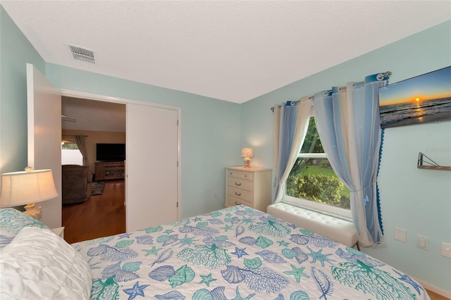 bedroom featuring hardwood / wood-style floors and a textured ceiling