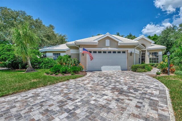 ranch-style house with a garage and a front lawn