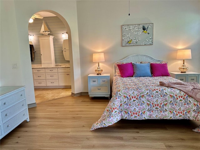 bedroom featuring light hardwood / wood-style flooring and ensuite bath