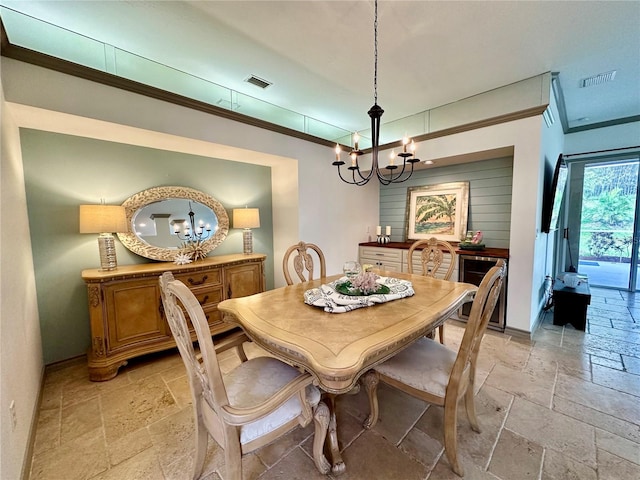 dining room featuring ornamental molding, wine cooler, and a chandelier