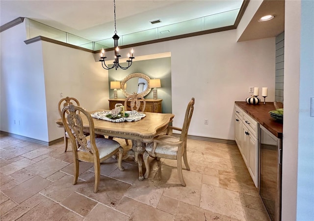 dining room featuring a chandelier, wine cooler, and crown molding