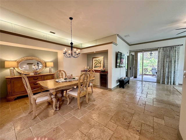 dining space featuring ceiling fan with notable chandelier, beverage cooler, and crown molding