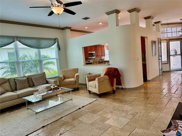 living room with ceiling fan and crown molding