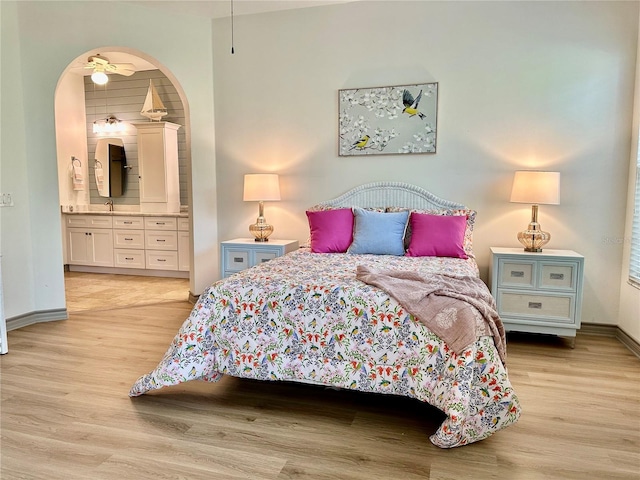 bedroom with ensuite bathroom and light wood-type flooring