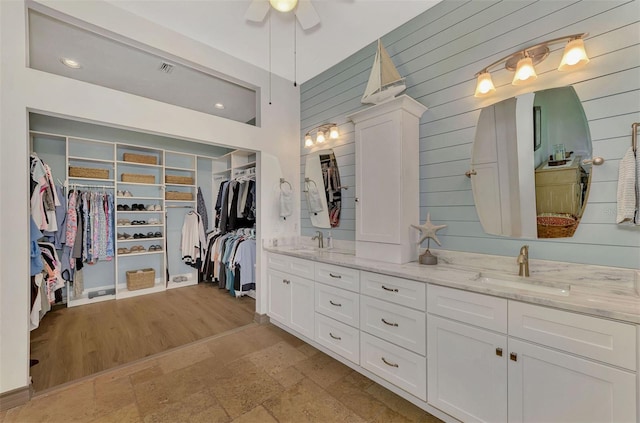 bathroom featuring hardwood / wood-style flooring, vanity, and wooden walls